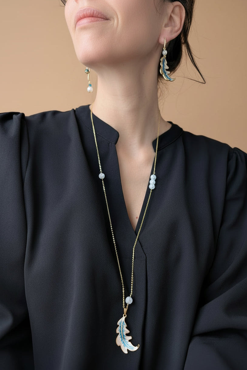 Parure Feuille d’Aurore avec boucles d’oreilles asymétriques – une feuille émaillée nacrée et bleue, l’autre avec perles de cristal de roche craquelé et apatite, et sautoir assorti avec pendentif feuille et perles de cristal de roche