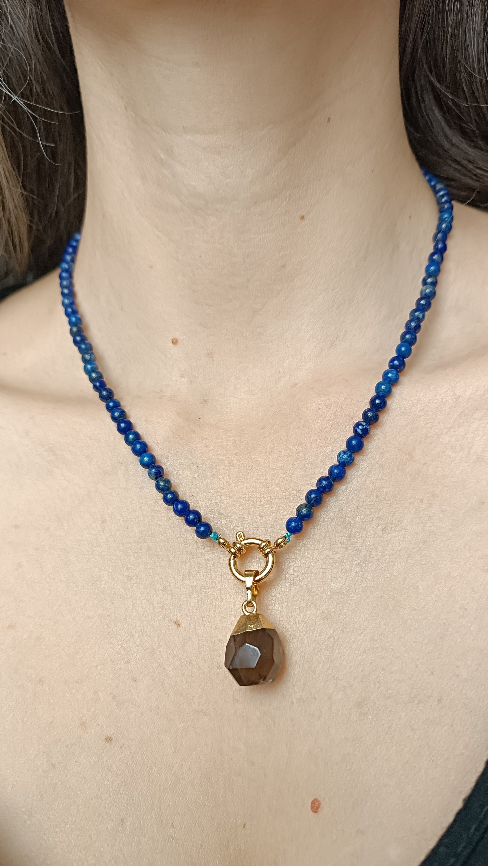 bijou naturel, élégance minérale, esprit bohème chic, énergie des pierres, style solaire, luxe discret, bleu profond, reflets dorés, pierre naturelle, quartz fumé, lapis-lazuli, texture minérale, lumière naturelle, fond pierre, travertin, sable clair, roche brute, lin naturel, bois clair, calme, force intérieure, équilibre, mystique, inspiration naturelle auroredecristal